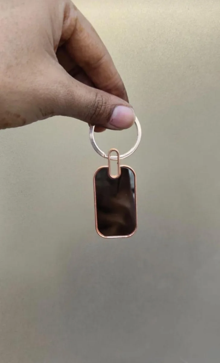 Black tag keychain with a rose gold rim